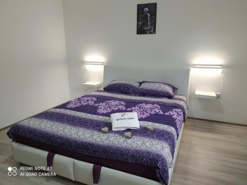 una camera con letto viola e 2 cuscini di Apartman Ljiljan a Soko Banja
