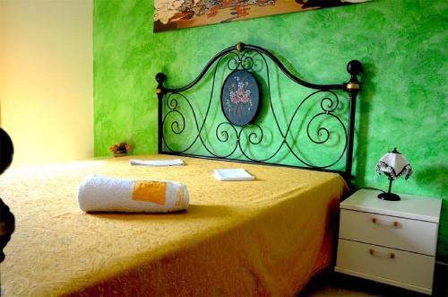 um quarto com uma cama com uma parede verde em B & B Baglio Mangiapane em Custonaci