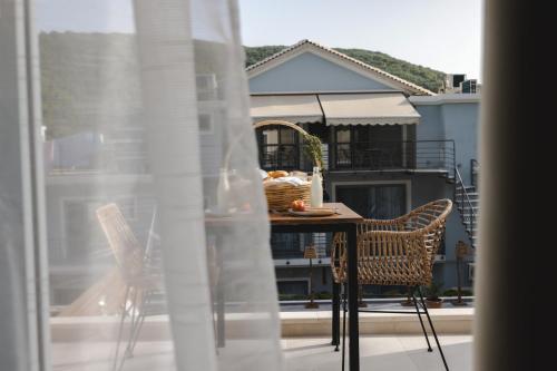 a table and chairs on a balcony with a view of a house at Liberte Maisonettes in Parga