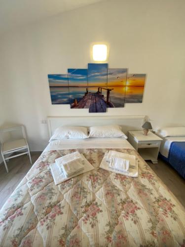 a bedroom with a bed with a painting on the wall at Molti Mari B&B Resort in Olbia