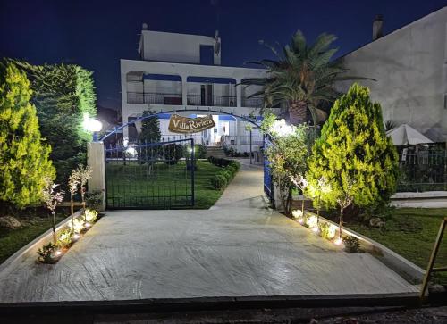 un vialetto che conduce a un edificio di notte di Villa Riviera a Stavros