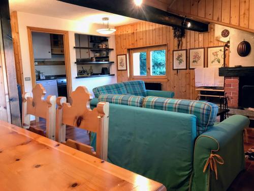 ein Wohnzimmer mit Sofas und einem Holztisch in der Unterkunft Chalet Apartment Gran Zebrù in 