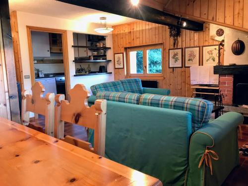 a living room with couches and a wooden table at Chalet Apartment Gran Zebrù in Oga