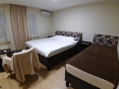 1 dormitorio con 1 cama, mesa y sillas en MiMOZA 2, en Jagodina
