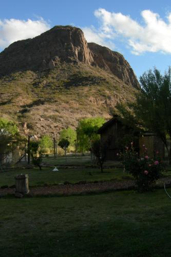 a mountain in the distance with a house in the foreground at Carü Leufu in Valle Grande