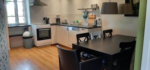 a kitchen with a table and chairs in a room at Le Papillon in Isserpent