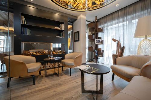 a living room with a fireplace and chairs at Locanda degli Artisti Art Hotel in Canazei