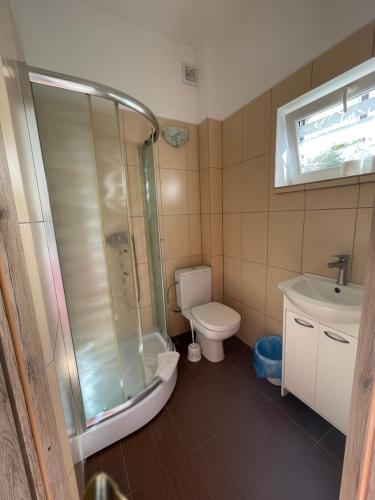y baño con ducha, aseo y lavamanos. en Pokoje Sztormowa 15 en Pogorzelica