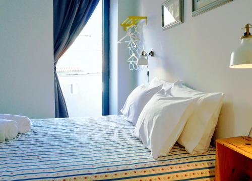 a bedroom with a bed with white pillows and a window at Hidden Gem w/ Rooftop - City Center & Douro View in Peso da Régua