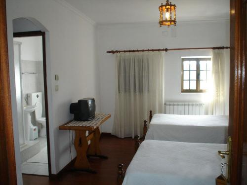 ein Hotelzimmer mit zwei Betten und einem Spiegel in der Unterkunft O ROCHA in Paredes do Rio