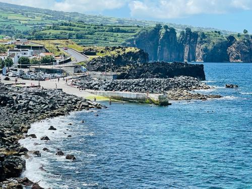 a beach with a group of people on the water at Azores Casa da Mata in São Vicente Ferreira