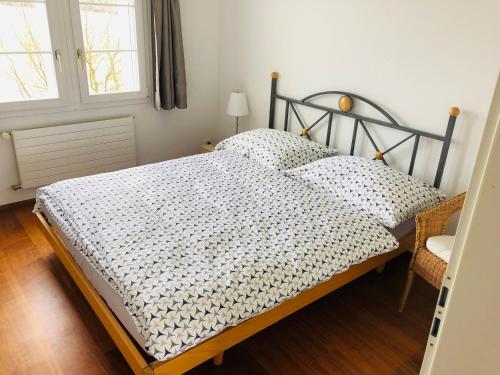 a bedroom with a bed and two windows at Apartment auf dem Bauernhof in Luzern