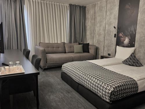 a hotel room with a bed and a couch at Vila Topaz in Baile Felix