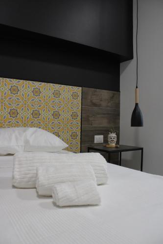 a bed with two white towels on top of it at Venere B&B Castelmola in Castelmola