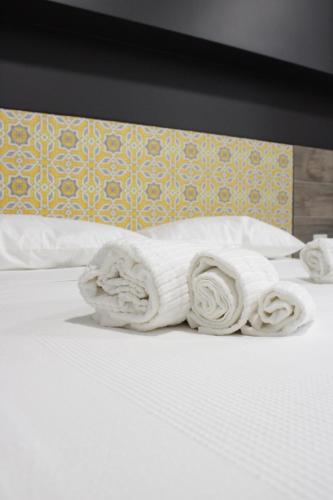 a pile of towels sitting on a bed at Venere B&B Castelmola in Castelmola