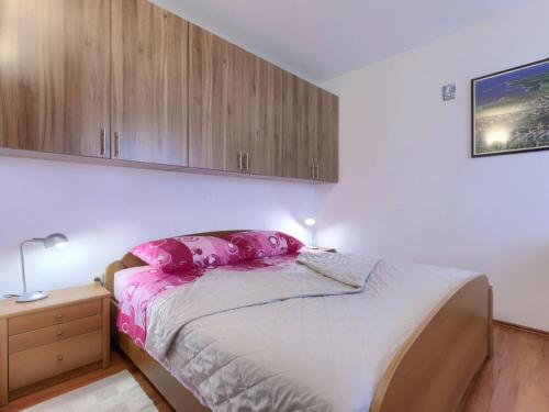 een slaapkamer met een bed met roze kussens erop bij Apartment Matej Premantura in Premantura