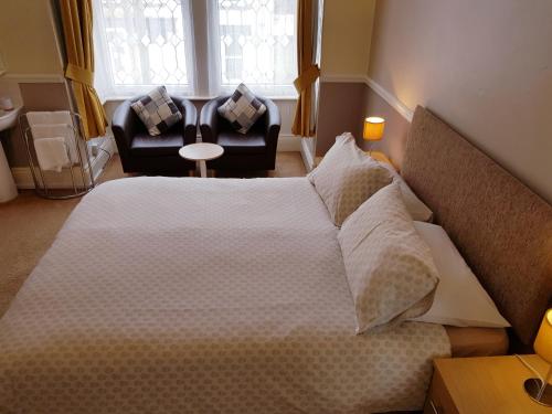 A bed or beds in a room at Marshall Lodge Guest House 