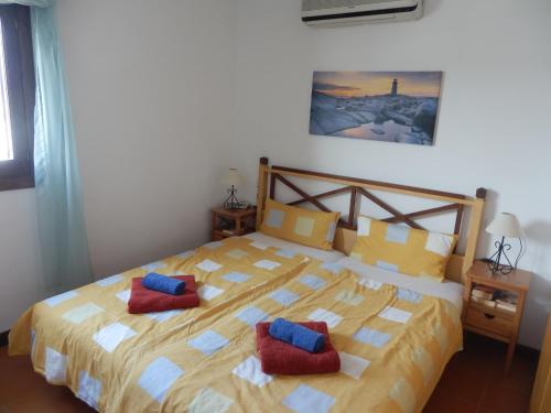 ein Schlafzimmer mit einem Bett mit zwei roten Kissen darauf in der Unterkunft Marina Dor II in Cala d´Or