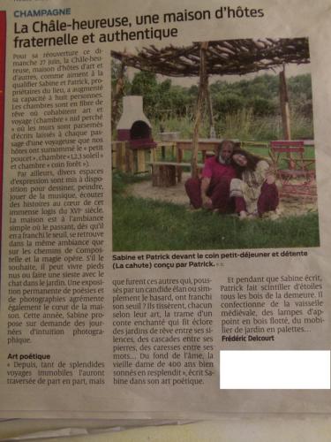 an article in a newspaper with a picture of two people at maison d'art et d'autres in Champagne
