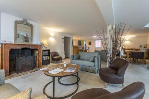 a living room with a couch and a fireplace at Hotel Le Clos Fleuri in Le Palais