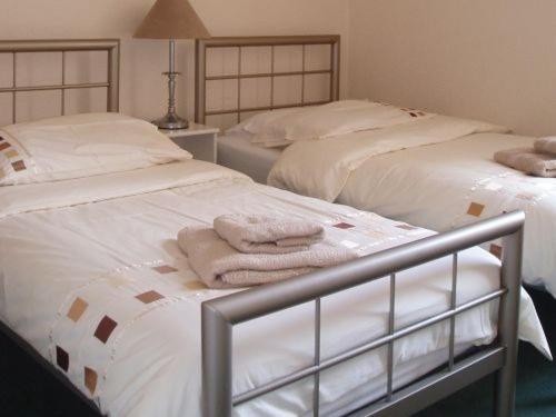 2 Betten mit Handtüchern in einem Schlafzimmer in der Unterkunft Breken Guest House in Exmouth