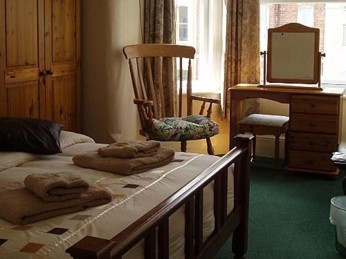 a bedroom with a bed and a dresser at Breken Guest House in Exmouth