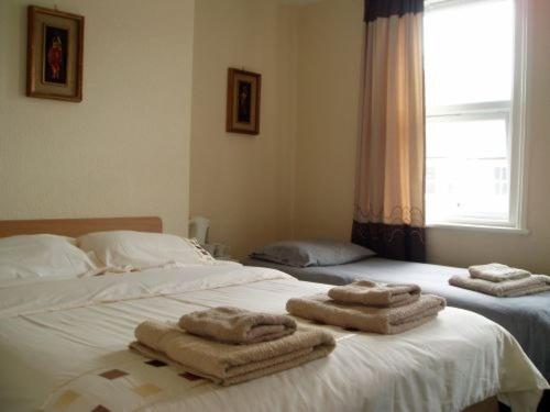 ein Schlafzimmer mit 2 Betten und Handtüchern darauf in der Unterkunft Breken Guest House in Exmouth