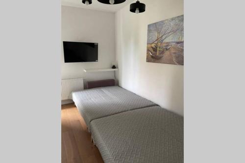 a bedroom with a bed and a flat screen tv at Apartament Seagull 30m2 (300 meters to the sea) in Hel