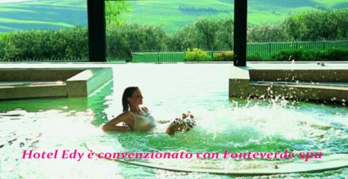 a woman laying in a pool in a swimming pool at Eco-Hotel Edy in Chianciano Terme