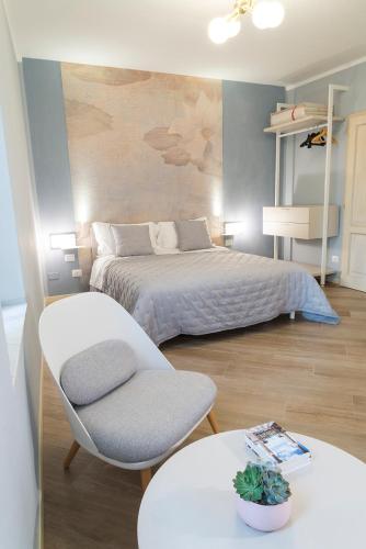 een slaapkamer met een bed, een stoel en een tafel bij Acquerello in San Quirico dʼOrcia