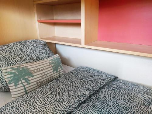 a bedroom with a bed and a pillow and shelves at Chez Adriana Studio VUE MER avec Piscine in Grimaud