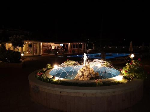 a fountain with lights in a park at night at Mediterranean Blue in Kavos