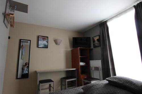 勒帕萊的住宿－Residence Hoteliere Sarah Bernard，一间卧室设有一张床、一台电视和一个窗口。