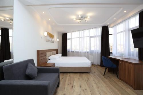 um quarto com uma cama, uma secretária e um sofá em Апарт отель Ривьера Парк em Sochi