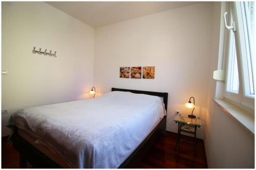 ein Schlafzimmer mit einem weißen Bett und einem Fenster in der Unterkunft Marit in Primošten