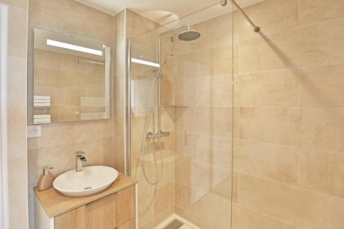 La salle de bains est pourvue d'un lavabo et d'une douche. dans l'établissement Vue panoramique mer et chenal même de la chambre 50m2 refait à neuf situation idéale en option garage fermé privé, à Les Sables-dʼOlonne