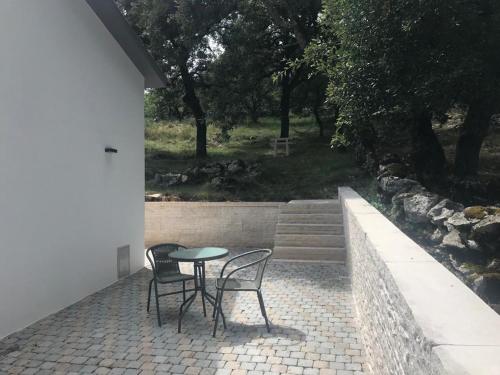 a table and two chairs on a brick patio at Recanto da Serra in Porto de Mós
