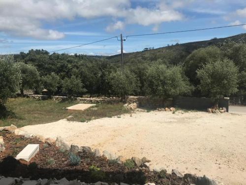 a park with a bench in the dirt at Recanto da Serra in Porto de Mós