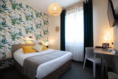 a hotel room with a bed and a desk and a window at Hotel De La Pommeraie in Le Mans