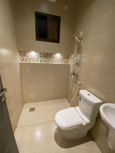 a white bathroom with a toilet and a sink at Platinum plus mirbat in Salalah