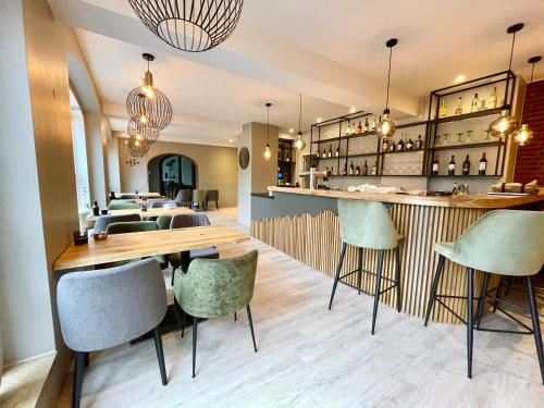 een restaurant met een bar met groene stoelen bij Hotel Schultheiss Hameln in Hameln