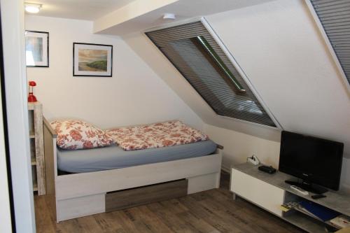 a small bedroom with a bed and a television at Grüner Blick in Witten