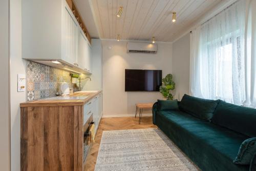 a living room with a green couch and a flat screen tv at Põlva Maja apartments - contactless check-in in Põlva