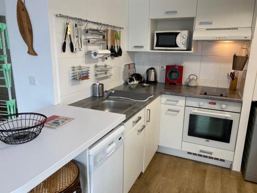 une petite cuisine avec un évier et un micro-ondes dans l'établissement Bêêê de Somme, à Saint-Valery-sur-Somme