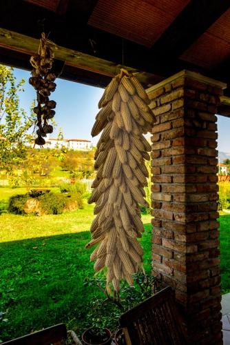 a bunch of onions hanging from a brick wall at MAXI SONCE, Odprte vasi in Prvačina
