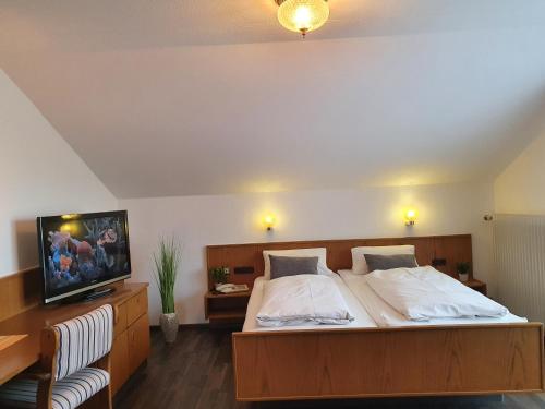 a bedroom with a large bed with a tv on it at Kurhotel Anders in Bad Füssing