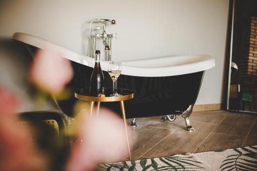 a black and white bath tub with a bottle and glasses of wine at Relais Almaranto in Calamandrana