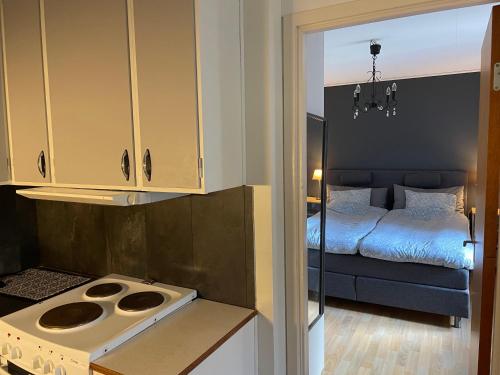 a kitchen with a stove and a bed in a room at Villa Tullgatan Borgholm in Borgholm