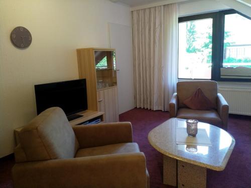 a living room with a couch and a table and a tv at Ferienhaus am Sonnenhang in Willingen