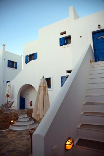 a white building with stairs and a blue door at Kanellis Studios in Avlemonas